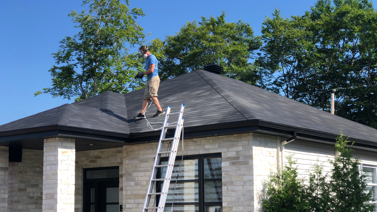 Technician treating a residential roof